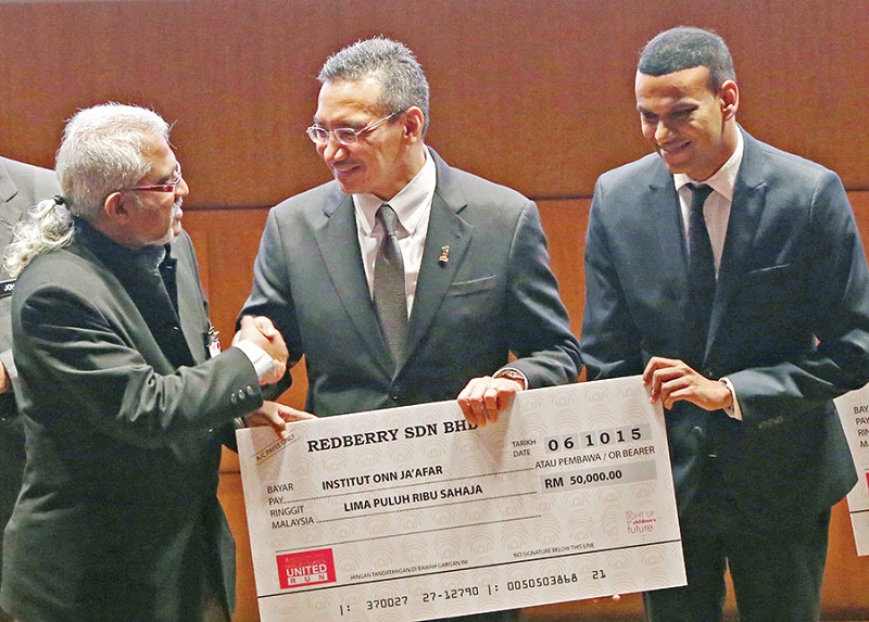 Redberry group marketing director Peter Anthony Das (left) presents a mock cheque for RM50,000 to Hishammuddin and Charles during the pre-launch ceremony of the run yesterday. u00e2u20acu201d Picture by Azneal Ishak