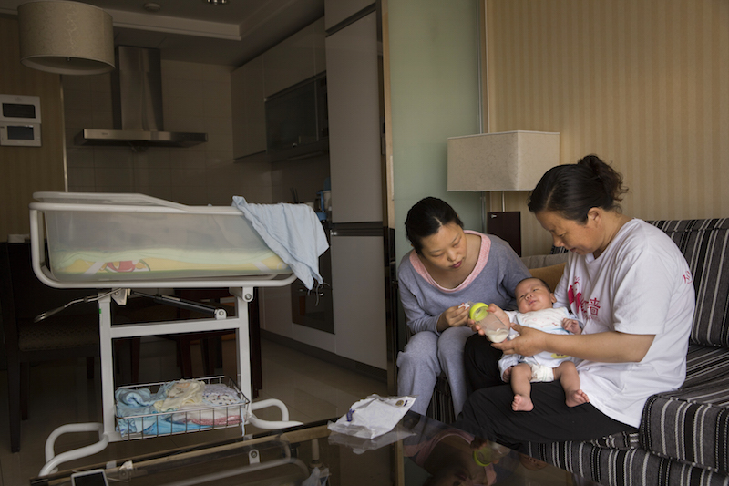 Li Rui, left, talks to her new baby Lei Yaoran as a nurse holds him at the Red Wall Mother and Baby Care Centre in Beijing, May 29, 2015. u00e2u20acu201d Picture Adam Dean/The New York Times