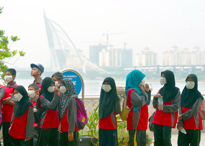 A group of students wearing masks and armed with mineral water, visit Putra Square in Putrajaya which is still shrouded in the haze with API reading of 101 on October 25, 2015. u00e2u20acu201d Bernama pic