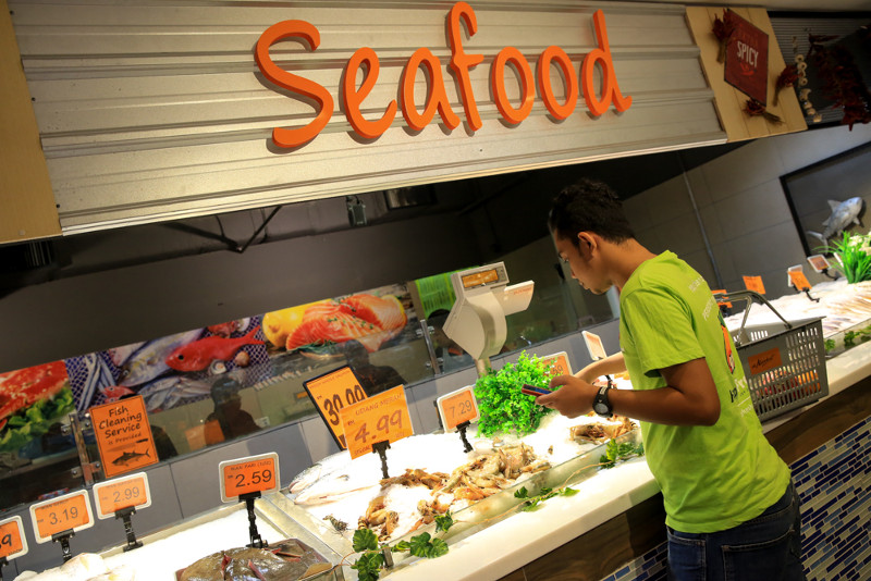 Happy Fresh personal shopper picking out fresh produce for customer.