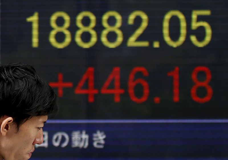 A man walks past an electronic board showing Japan's Nikkei average outside a brokerage in Tokyo, October 23, 2015. u00e2u20acu201d Reuters pic