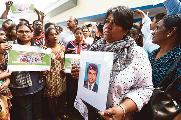 Satiavani holds a photograph of Gobalaguru during the gathering at Bukit Aman. She and the family members of eight alleged victims of abduction want to know the fate of their loved ones. u00e2u20acu201d Picture by Ahmad Zamzahuri 