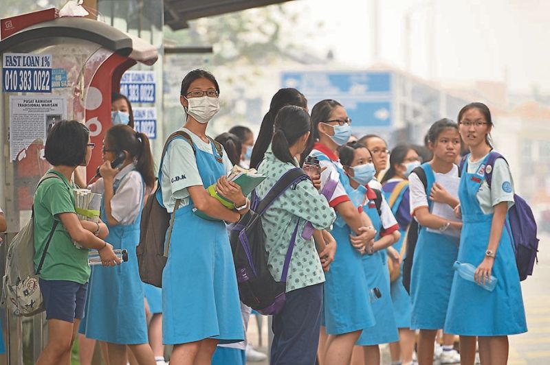 Students going to school despite the haze in Penang yesterday. u00e2u20acu201d Picture by R. Mahgeshan