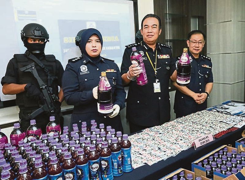 Datuk Mohd Dzuraidi Ibrahim (second right) shows bottles of the drug-laced drinks. u00e2u20acu201d Picture by Kwong Wah