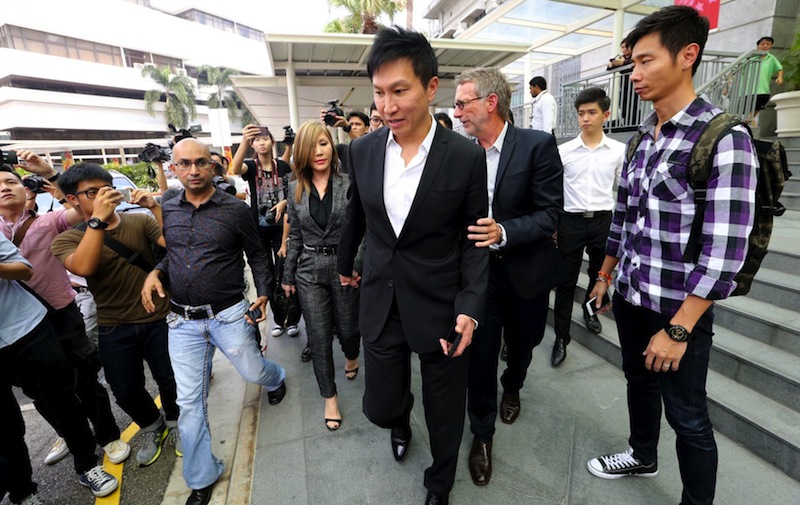 Kong Hee (centre) and his wife Sun Ho leaving the State Courts today after the verdict. u00e2u20acu201d TODAY pic