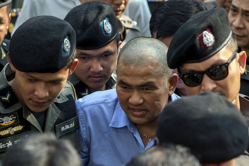 Thailand's lese-majeste suspect Suriyan Sujaritpalawong (centre) is escorted by police officer as he arrives at military court in Bangkok, October 21, 2015. u00e2u20acu201d Reuters pic