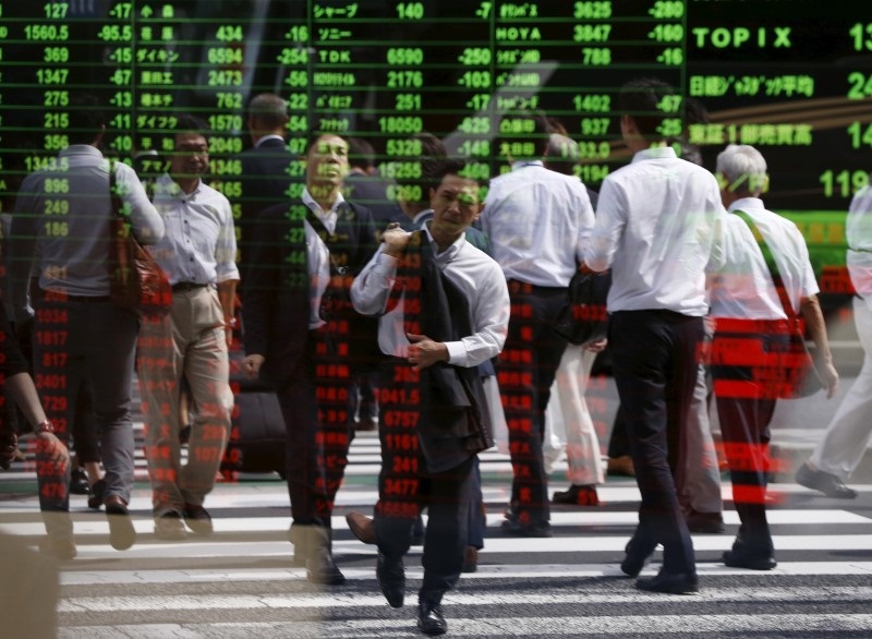 Passersby are reflected on a stock quotation board at a brokerage in Tokyo, Japan, September 29, 2015. u00e2u20acu201d Reuters pic