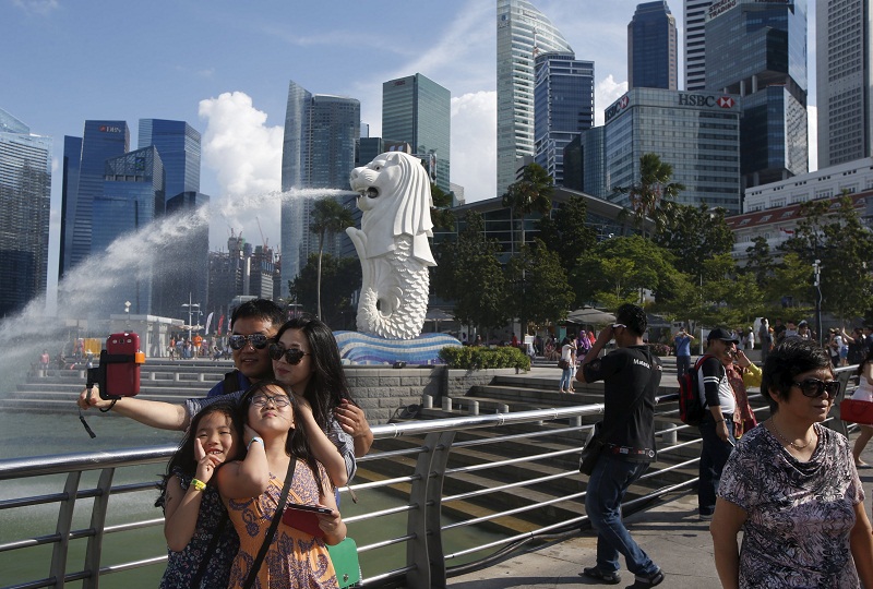 Tourists take photos by the famous Merlion fountain in Singapore July 29, 2015. u00e2u20acu201d Reuters pic