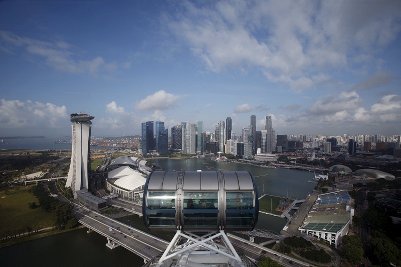 People sit in a cabin on the Singapore Flyer observatory wheel overlooking the skyline of the central business district in Singapore July 16, 2015. u00e2u20acu201d Reuters pic