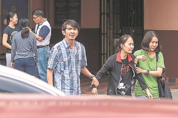 Hon Yeu00e2u20acu2122s mother (second from right) was heart-broken after identifying Honu00e2u20acu2122s (inset) remains at the Selayang Hospital. u00e2u20acu201d Picture by Malay Mail