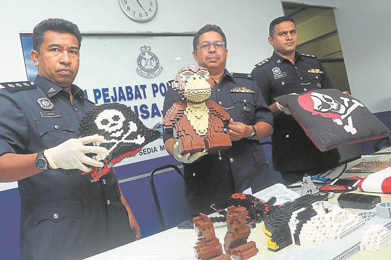 Ismail (centre) and Nusajaya police officers show some of the Lego items recovered. u00e2u20acu201d Picture by Malay Mail