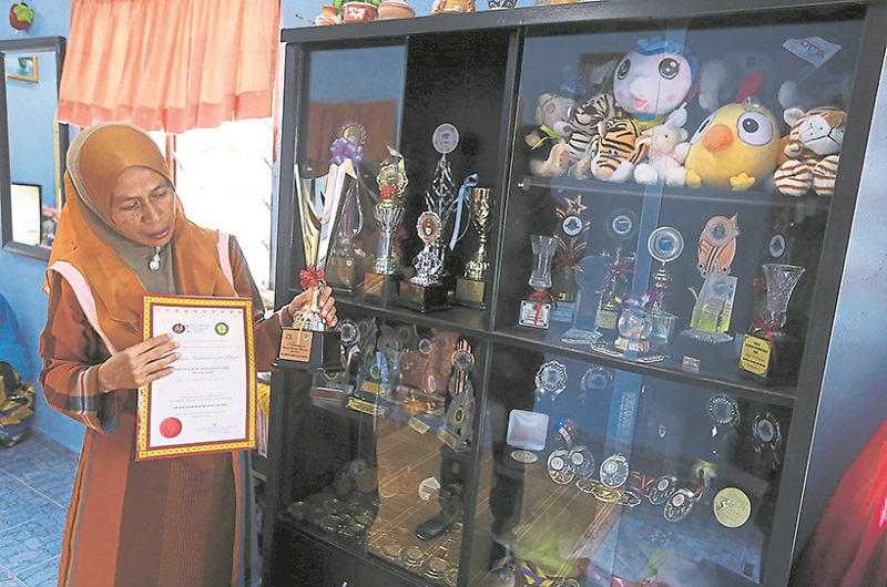 Rozinah says she always looks at the trophy cabinet when she misses Badrul. u00e2u20acu201d Picture by Malay Mail
