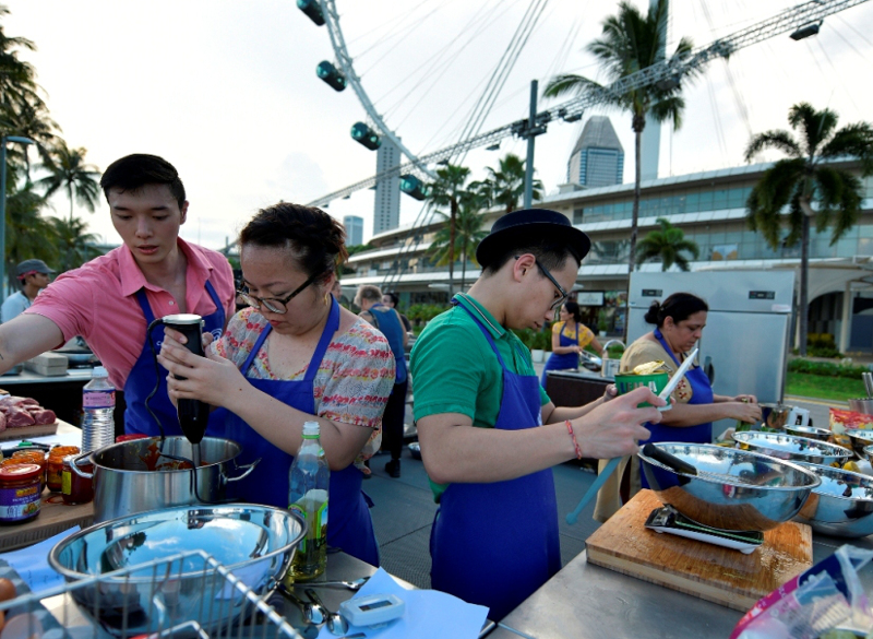 Malaysian contestants Jasbir Kaur (far right) and Marcus Low (2nd right) cooking together in the same team during one of the earlier episodes of the season. — Picture by Masterchef Asia