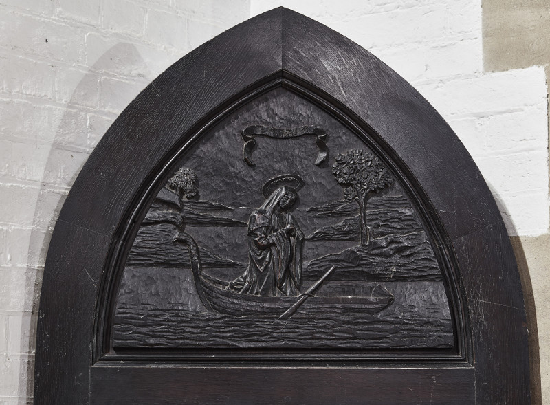 A carved wooden door panel in St Frideswide church, depicting St Frideswide returning from her exile in Binsey, in Oxford, England, October 2015.