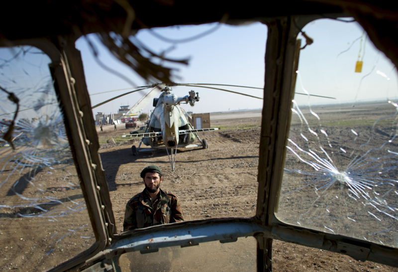 A soldier of the Afghan National Army (ANA) is seen through the cockpit of a derelict Russian helicopter as he guards Kunduz airport in this December 10, 2011 file photo. u00e2u20acu201d Reuters pic