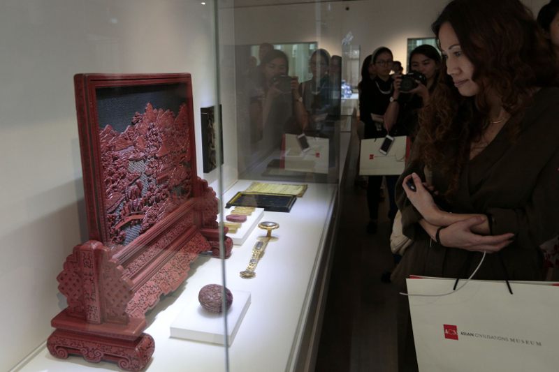 A woman views a lacquered wood table screen depicting a gathering of scholars at the Asian Civilisations Museum, November 9, 2015. u00e2u20acu201d Jason Quah/TODAY pic