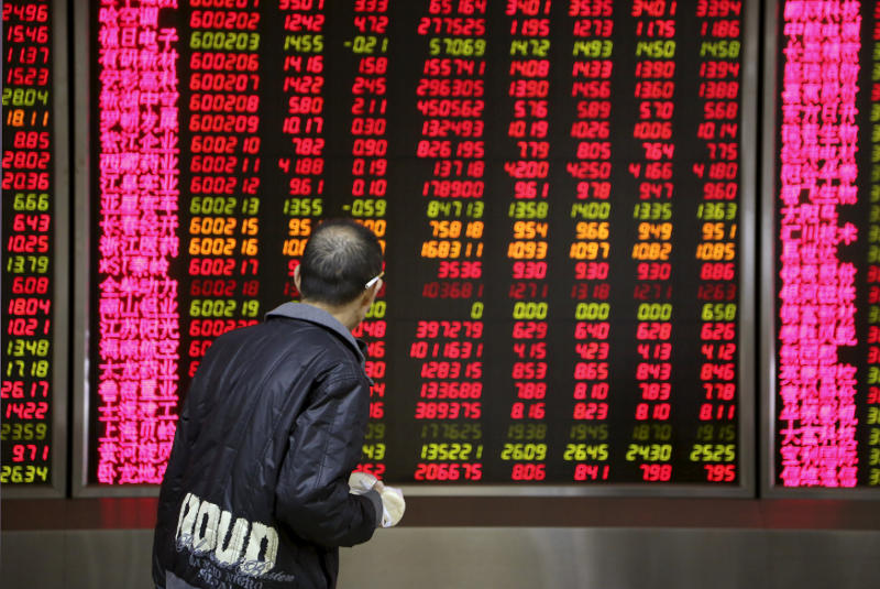 An investor walks past in front of an electronic board showing stock information at a brokerage house in Beijing, China, November 17, 2015. u00e2u20acu201d Reuters pic