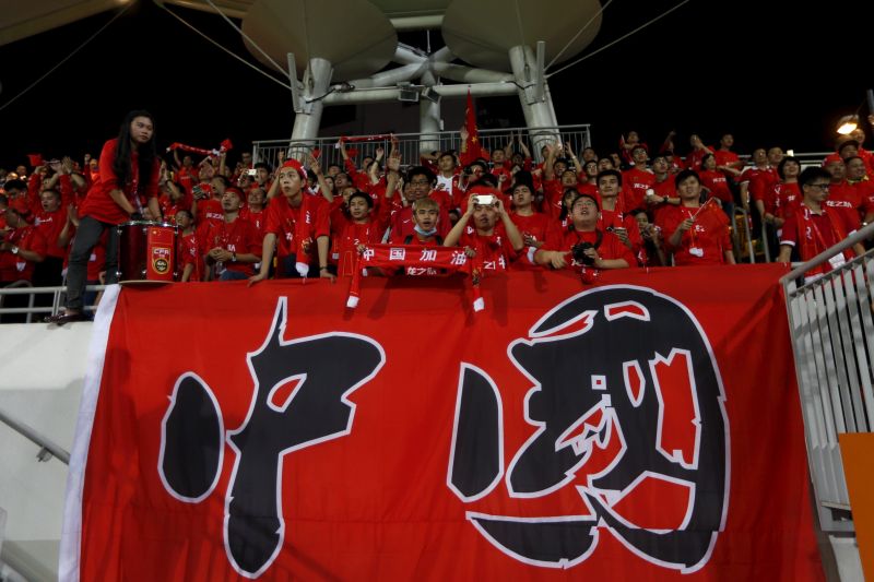 Chinese fans chant slogans before the match.