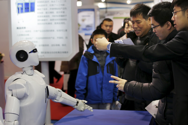 Visitors gesture to a KINGER Robot at the World Robot Exhibition during the World Robot Conference in Beijing November 24, 2015. — Reuters pic