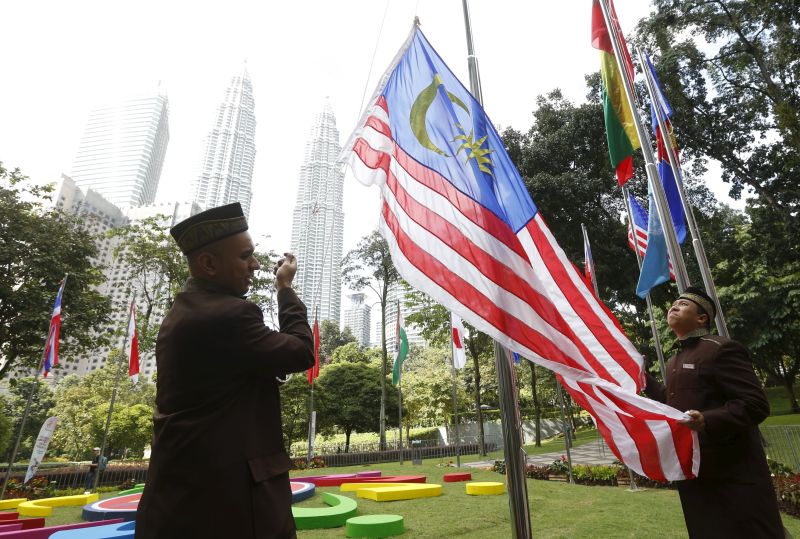 Workers raise the Malaysian flag outside the venue for the 27th Association of Southeast Asian Nations (Asean) summit in Kuala Lumpur, Malaysia, November 19, 2015. u00e2u20acu2022 Reuters pic