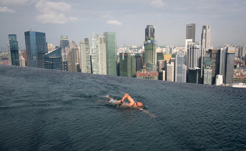 A guest swims in the infinity pool at the top the Marina Bay Sands hotel in Singapore, in this June 24, 2010 file photo. Singapore economy grew much faster than initially estimated in the third quarter. u00e2u20acu201d Reuters pic