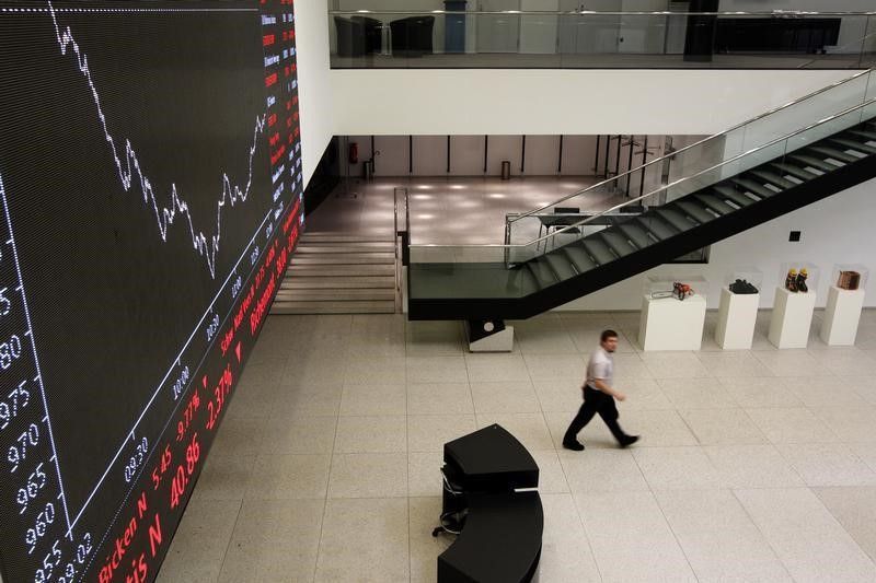 A man walks past an information billboard showing the evolution of the FTSE 100 index at the Swiss exchange in Zurich, August 9, 2011. REUTERS/Christian Hartmann
