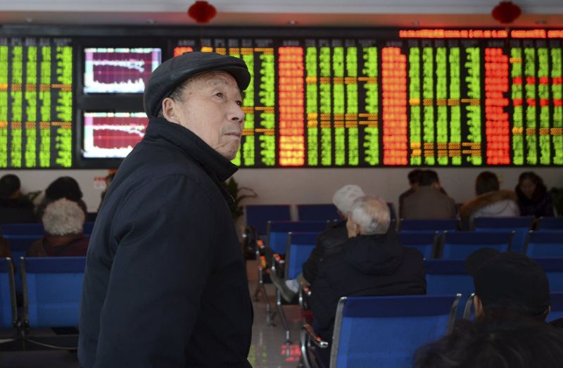 An investor looks on in front of an electronic board showing stock information at a brokerage house in Fuyang, Anhui province, China, November 27, 2015. REUTERS/China Daily