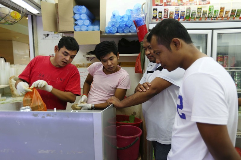 Customers and storekeepers alike gather round to watch the live telecast of the results on the handphone. u00e2u20acu201d TODAY pic