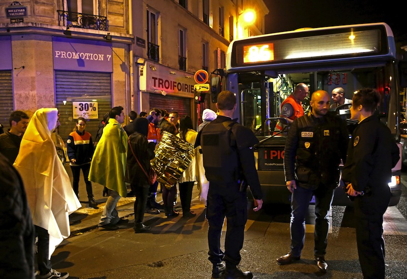 French police stand near people warming up on a street before being evacuated by bus near the Bataclan concert hall following fatal attacks in Paris, France, November 14, 2015. u00e2u20acu201d Reuters pic