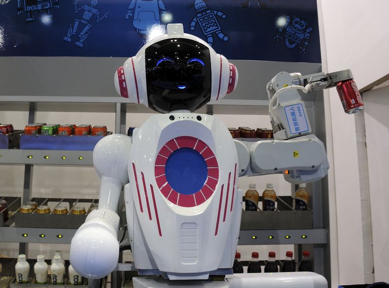 A sales assistant robot picks up a can of Coca Cola during a demonstration at the World Robot Conference in Beijing November 24, 2015. — Reuters pic