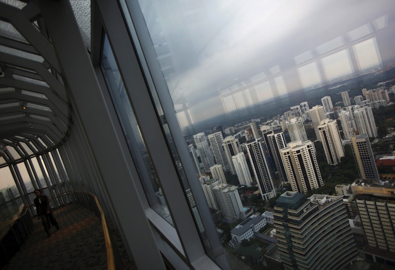 People walk on an observation deck overlooking private high-rise residential condominium properties in the prime Orchard Road district in Singapore in this April 15, 2014 file photo.u00c2u00a0u00e2u20acu201d Reuters pic