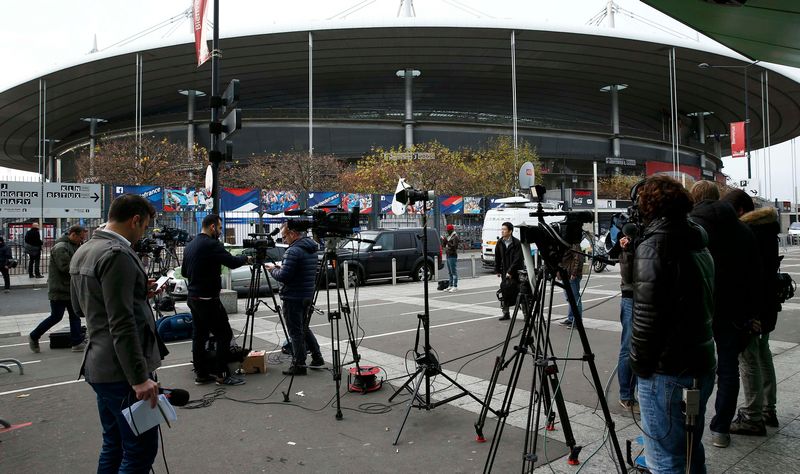 Media stand behind a barrier in front of the Stade de France stadium the morning after a series of deadly attacks in Paris, November 14, 2015. u00e2u20acu201d Reuters picn