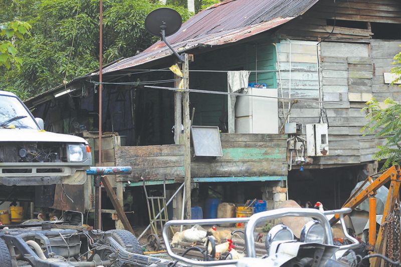 The dilapitated house where the family of four lived. The compound is strewn with old tyres and discarded motor parts. u00e2u20acu201d Pictures by Farhan Najib