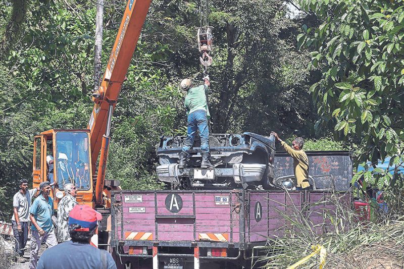 A crane and a lorry had to be used to remove a partial vehicle. u00e2u20acu201d Picture by Farhan Najib Yusoff
