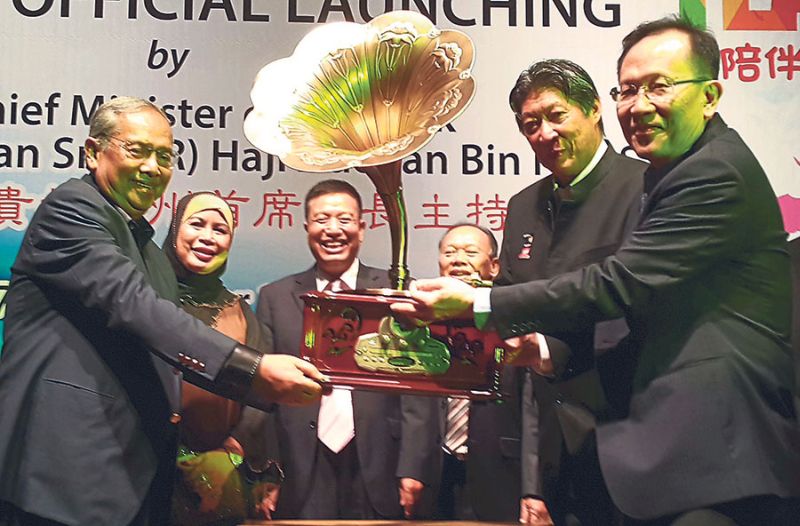 Sarawak Chief Minister Tan Sri Adenan Satem (left) receiving a gramophone from KTS Group chief executive officer and managing director Datuk Henry Lau (right) and Redberry group chief executive officer and Ancom Berhad group managing director Datuk Siew K