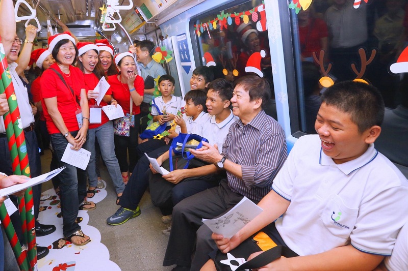 Singapore Minister of Transport Khaw Boon Wan took the Christmas-themed train with students from Pathlight School from Ang Mo Kio MRT Station at its launch today (December 14), as carollers look on. u00e2u20acu201d TODAY Pic