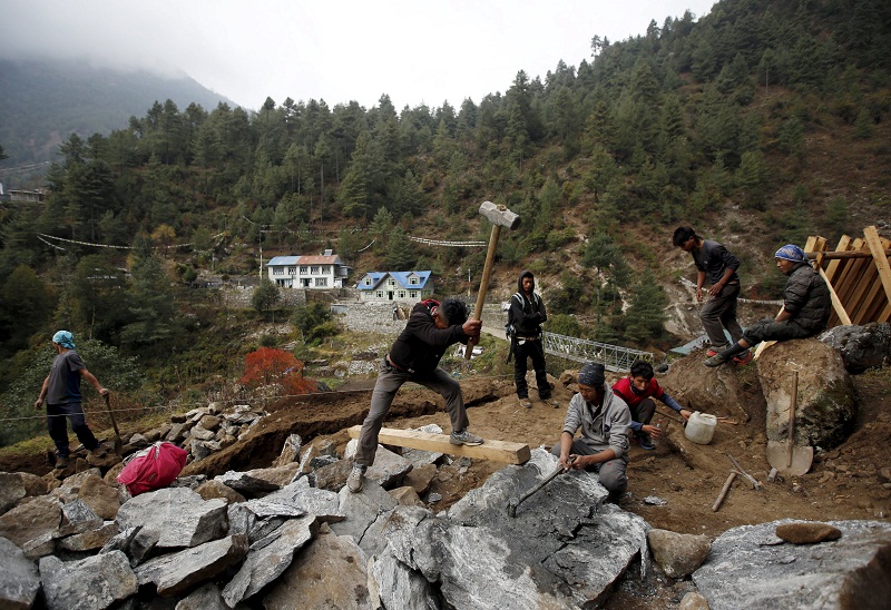 Men work to break stones to build houses after the earthquake earlier this year in Solukhumbu District, also known as the Everest region, in this picture taken November 28, 2015. — Reuters pic