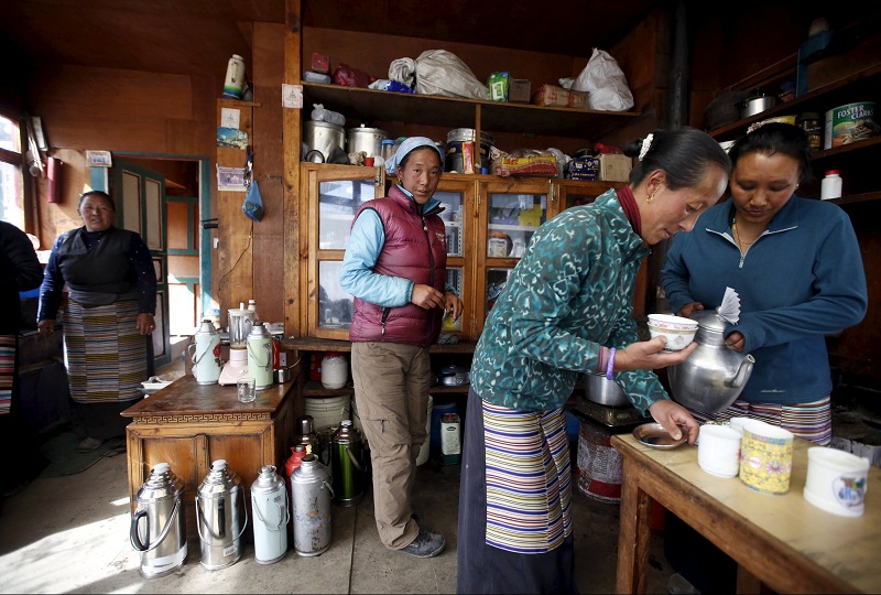 Karma Doma Sherpa (centre), wife of Phurbha Tashi Sherpa a 21-time Everest summiteer, works inside the kitchen of her house at Khumjung, a typical Sherpa village in Solukhumbu district also known as the Everest region, in this picture taken November 30, 2