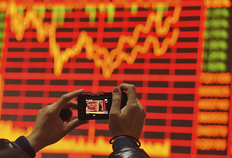 An investor takes pictures of an electronic screen showing stock information at a brokerage house in Fuyang, Anhui province, China, December 24, 2015. u00e2u20acu201d Reuters pic
