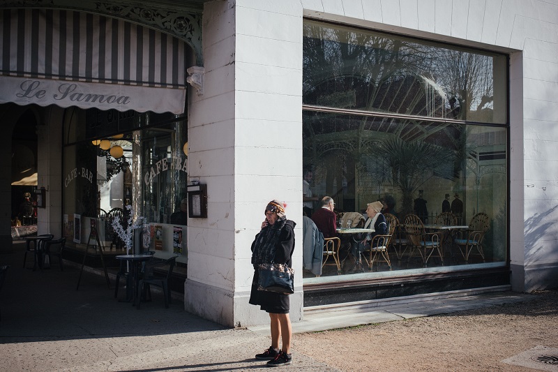 A pedestrian on her phone outside a cafe in downtown Vichy, December 12, 2015. ― Picture by Dmitry Kostyukov/The New York Times