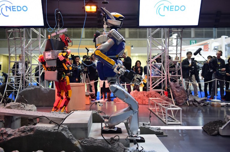 A humanoid robot HRP-2, produced by Kawada, walks amongst mock debris scattered on the ground during the annual International Robot Exhibition in Tokyo December 2, 2015. u00e2u20acu201d AFP pic