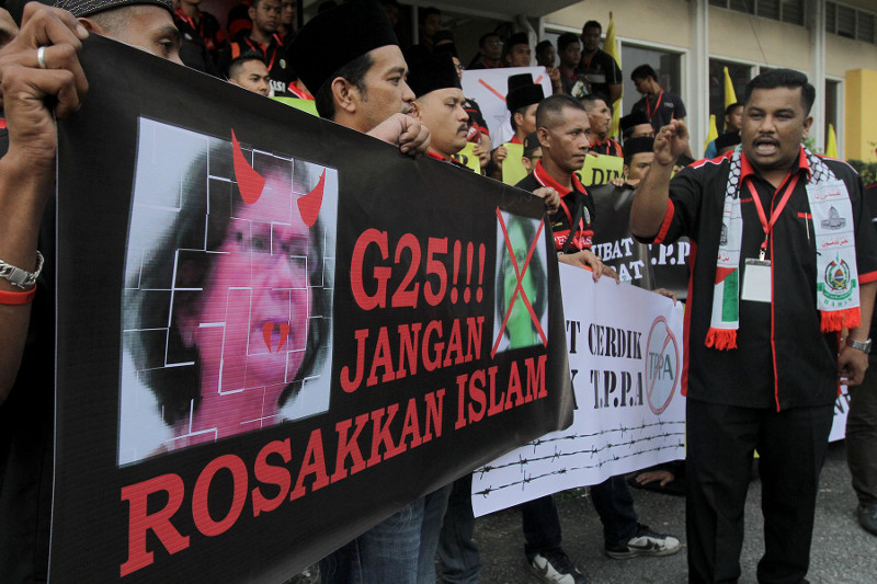 Perkasa members hold a banner slamming G25 at the Perkasa assembly in Kuala Lumpur, December 19, 2015. u00e2u20acu2022 Picture by Yusof Mat Isa