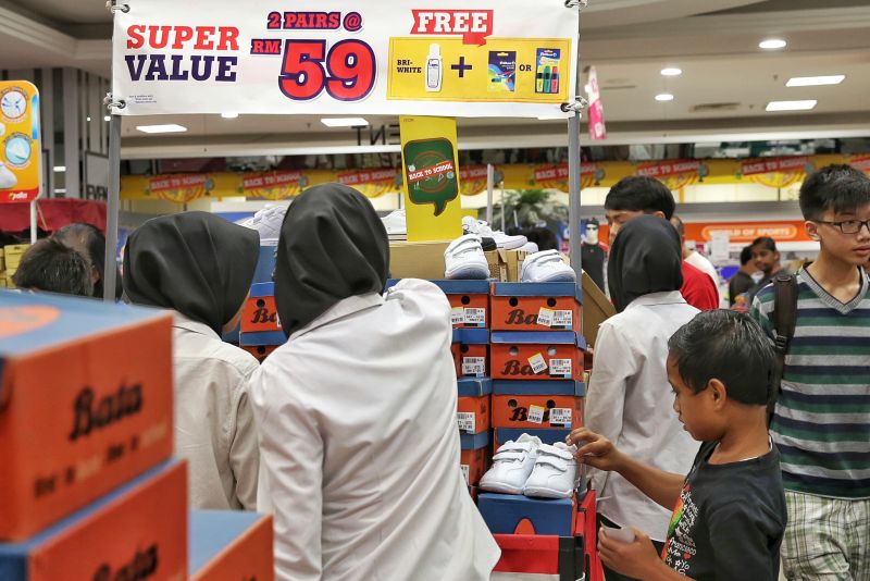 Parents with their children shop for shoes to prepare for the new school term, Kuala Lumpur, December 28, 2015. u00e2u20acu201d Picture by Saw Siow Feng