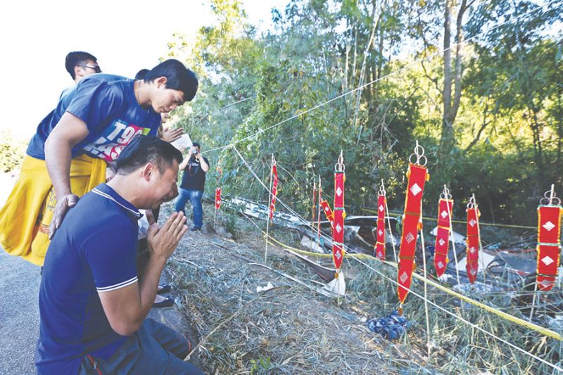 Tan Sien Nian prays near the wreckage of the bus. He lost his grandmother Low Chee Lan, sister Tan Thin Thin, aunty Tan Sui Heng and uncle Ker Bong Ngwang. u00e2u20acu2022 Picture by Azneal Ishak