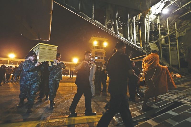 A monk leads casket bearers as the victimsu00e2u20acu2122 remains are loaded onto an RMAF aircraft for the flight to Subang. u00e2u20acu201d Picture by Azneal Ishak