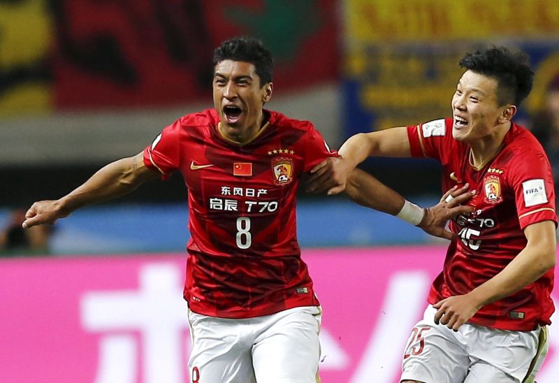 Paulinho (left) celebrates after scoring the winner, trailed by teammate Zou Zheng.