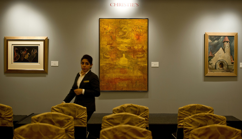 Vasudeo S. Gaitondeu00e2u20acu2122s u00e2u20acu02dcUntitledu00e2u20acu2122 (centre), Rabindranath Tagoreu00e2u20acu2122s u00e2u20acu02dcUntitledu00e2u20acu2122 (left) and Amrita Shergilu00e2u20acu2122s u00e2u20acu02dcUntitled-Hungarian Village Churchu00e2u20acu2122 paintings are pictured during a media preview ahead of Christieu00e2u20acu2122s first auction in New Delhi De