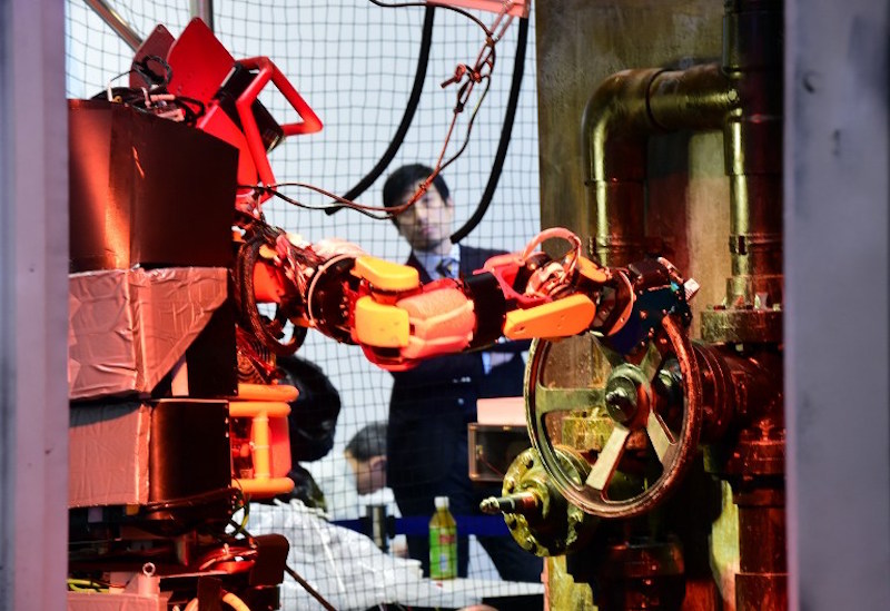 Humanoid robot Jaxon, produced by Tokyo University, turns a handle of a valve during a demonstration of how the robot would work within a disaster area at the annual International Robot Exhibition in Tokyo December 2, 2015. — AFP pic