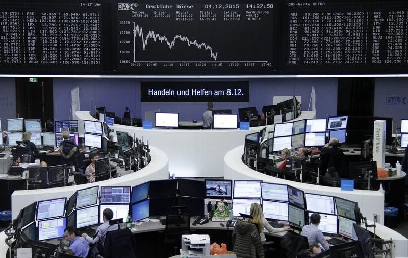 Traders at their desks in front of the DAX board at the stock exchange in Frankfurt, December 4, 2015. Reuters/Staff/Remote