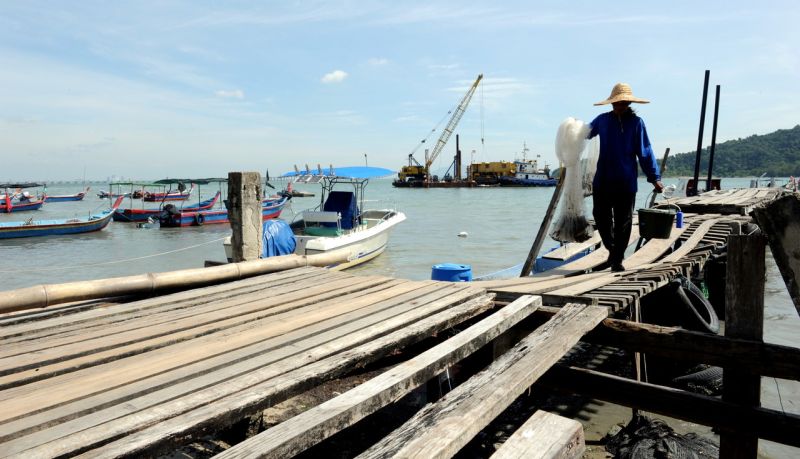 A fisherman is seen bringing back his daily catch at Bayan Bay in Penang, December 22, 2015. u00e2u20acu2022 Bernama pic